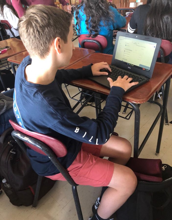 Austin Cincotta, freshman, starts of his Chromebook as class begins. He is one of over 500 freshmen who received the device.