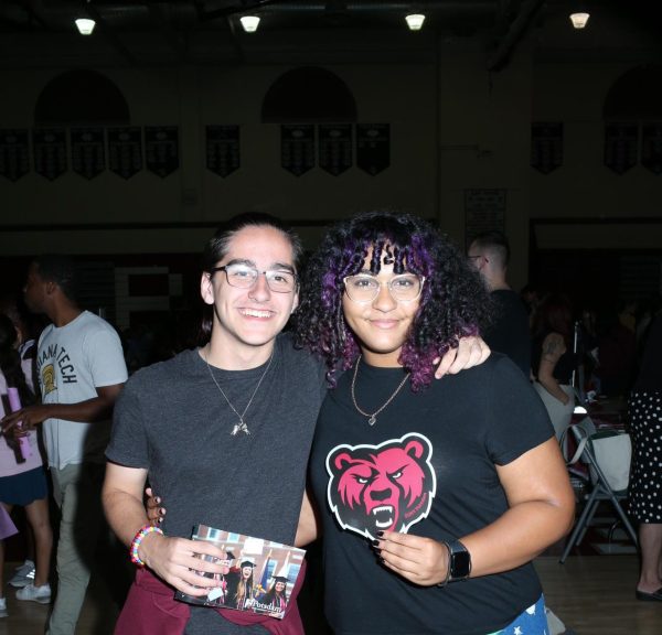 Junior Riley Silva is accompanied by Junior Milkayla Herbert at the college and career fair. They are each holding a souvenir that they have received after visiting college booths that peaked their interest.