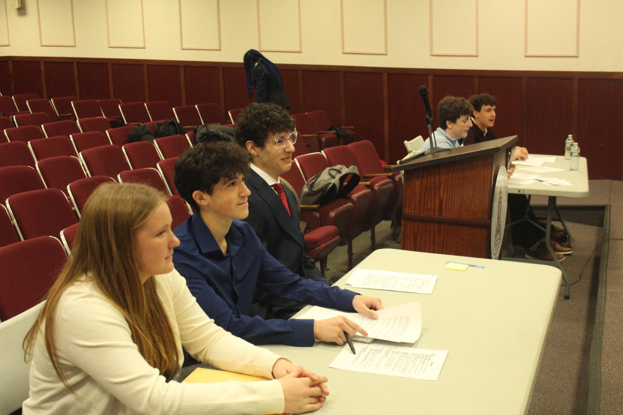 Students Kennedy Lyden, Marcus Campos and Tanner Wissmann preparing to present their case in front of a judge.